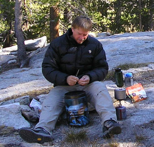Hungry hiker cooks dinner